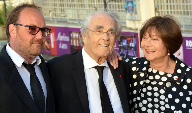 Michel Legrand souriant entre le réalisateur Xavier Beauvois et l'actrice Macha Méril, sur le tapis rouge