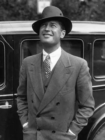 Maurice Chevalier souriant en chapeau devant une automobile, 1929