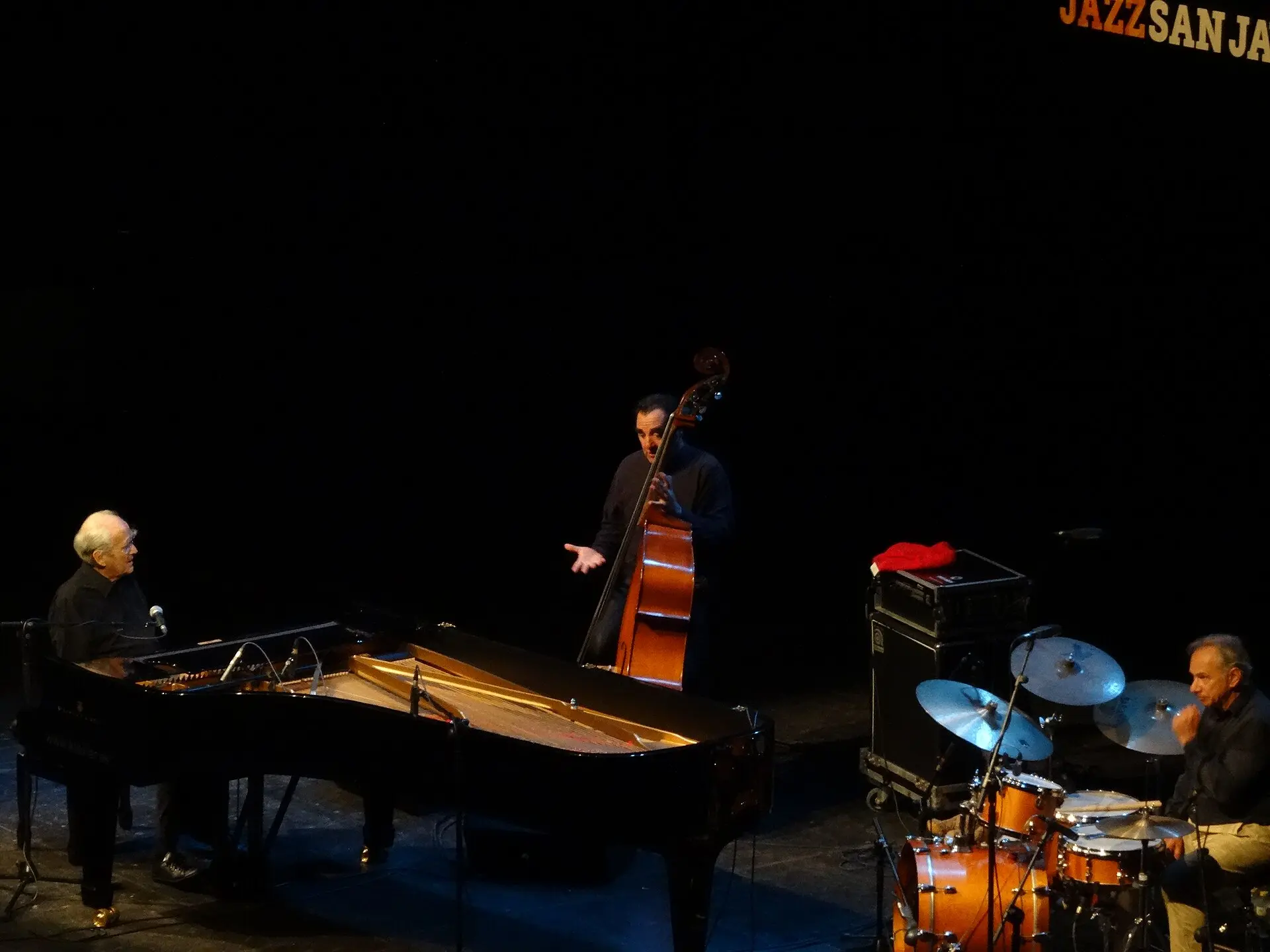 Vue large de la scène : Michel Legrand au piano, contrebasse et batterie